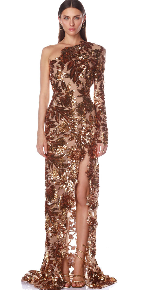 Woman wearing a long, one-shoulder sequin dress with a high slit on a white background